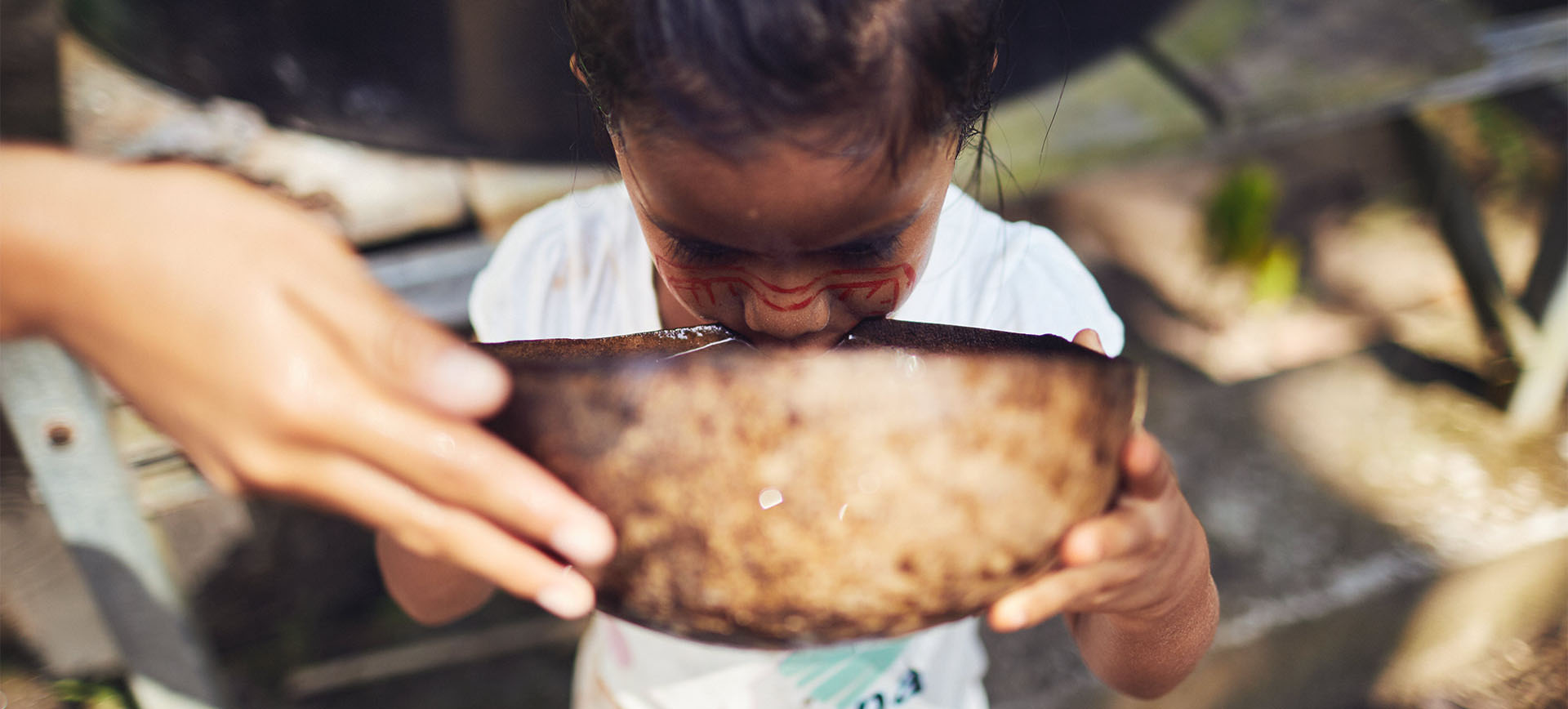 Kind trinkt Wasser im Amazonas-Regenwald Ecuador