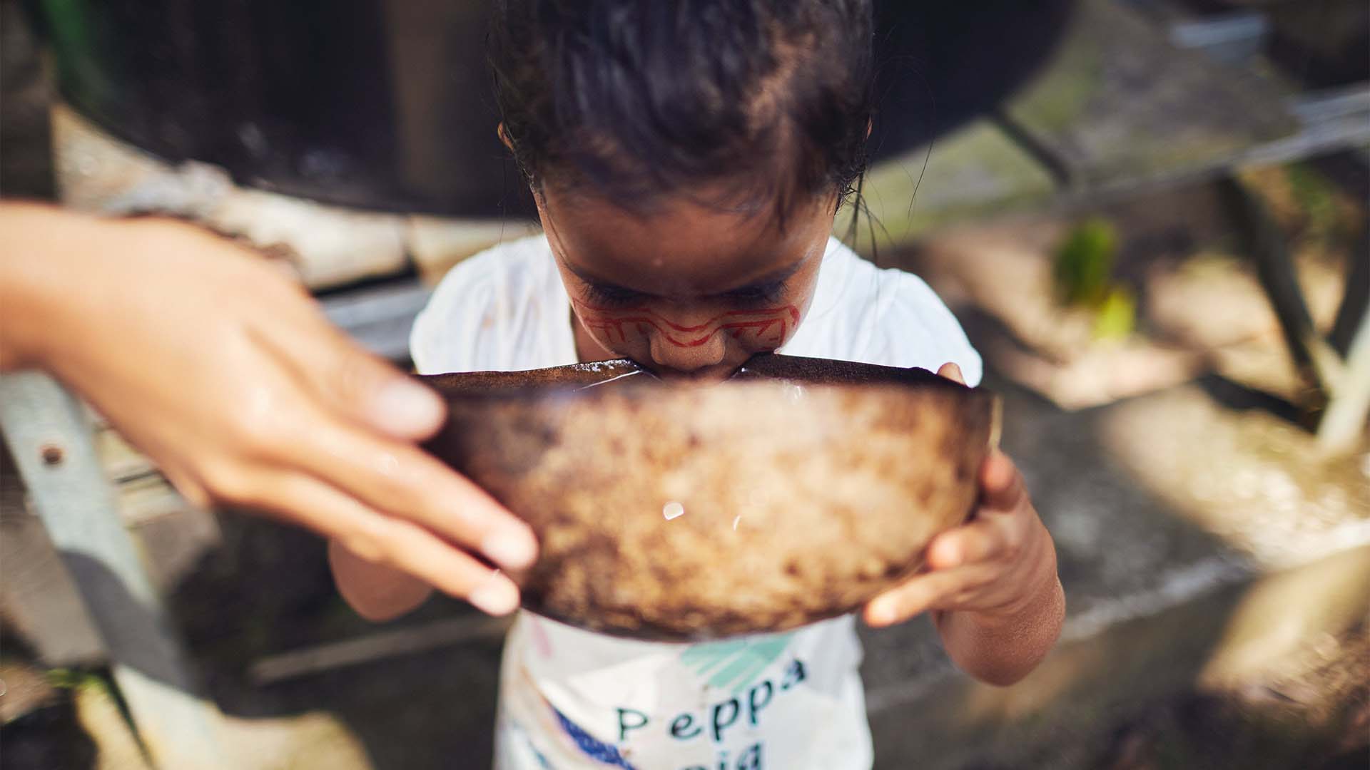 Kind trinkt Wasser im Amazonas-Regenwald Ecuador