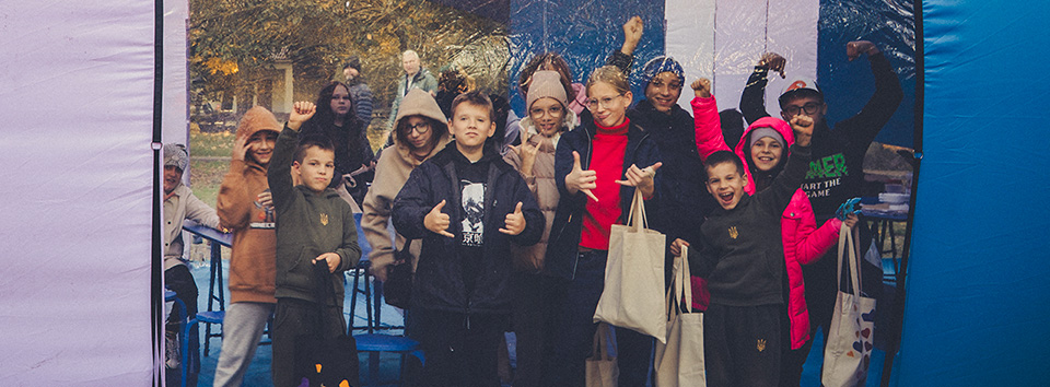 Ukrainische Kinder beim kreativen Workshop im mobilen UNHIDE Pop Hub der Stiftung Saving an Angel, Oktober 2024